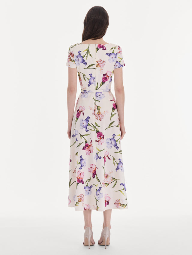 The model is wearing a short sleeve iris flowers poplin day dress. Back view.