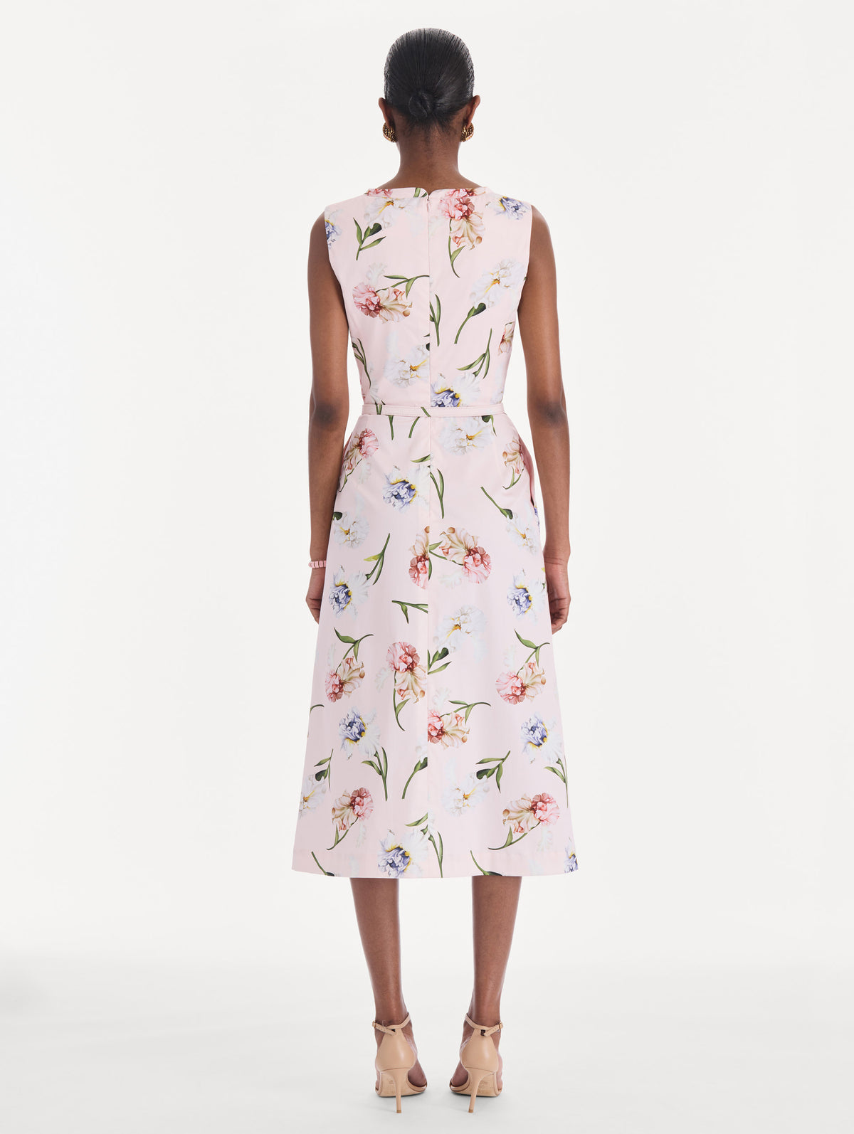 The model is wearing a sleeveless painted iris poplin day dress. Back view.