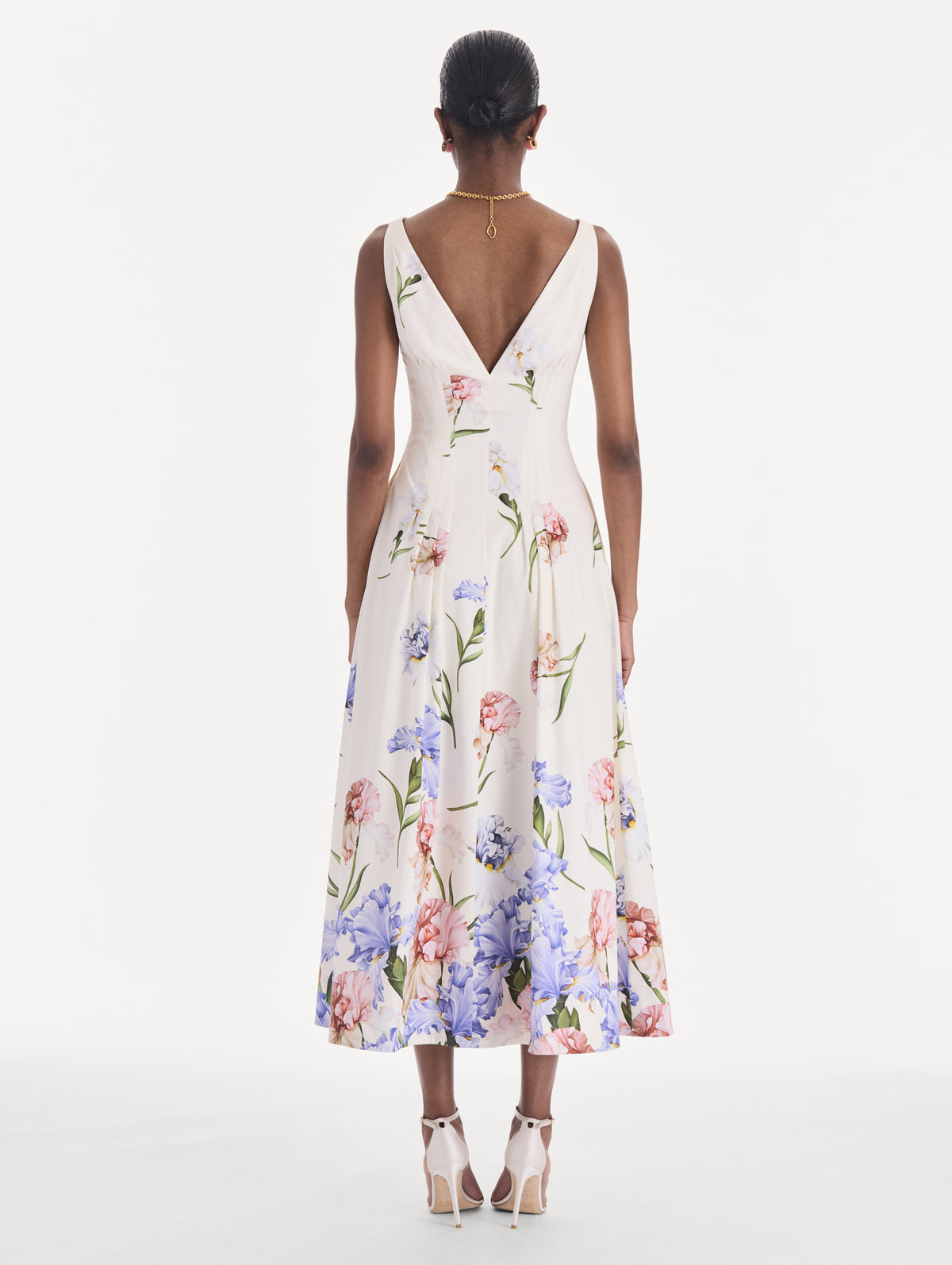 The model is wearing a sleeveless V-neck large iris degrade poplin dress. Back view.