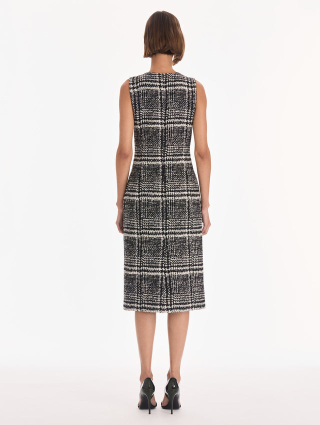 The model is wearing a sleeveless glen plaid boucle tweed day dress. Back view.