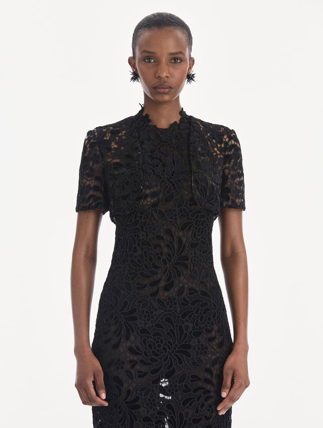 The model is wearing a short sleeve cape. Front view.