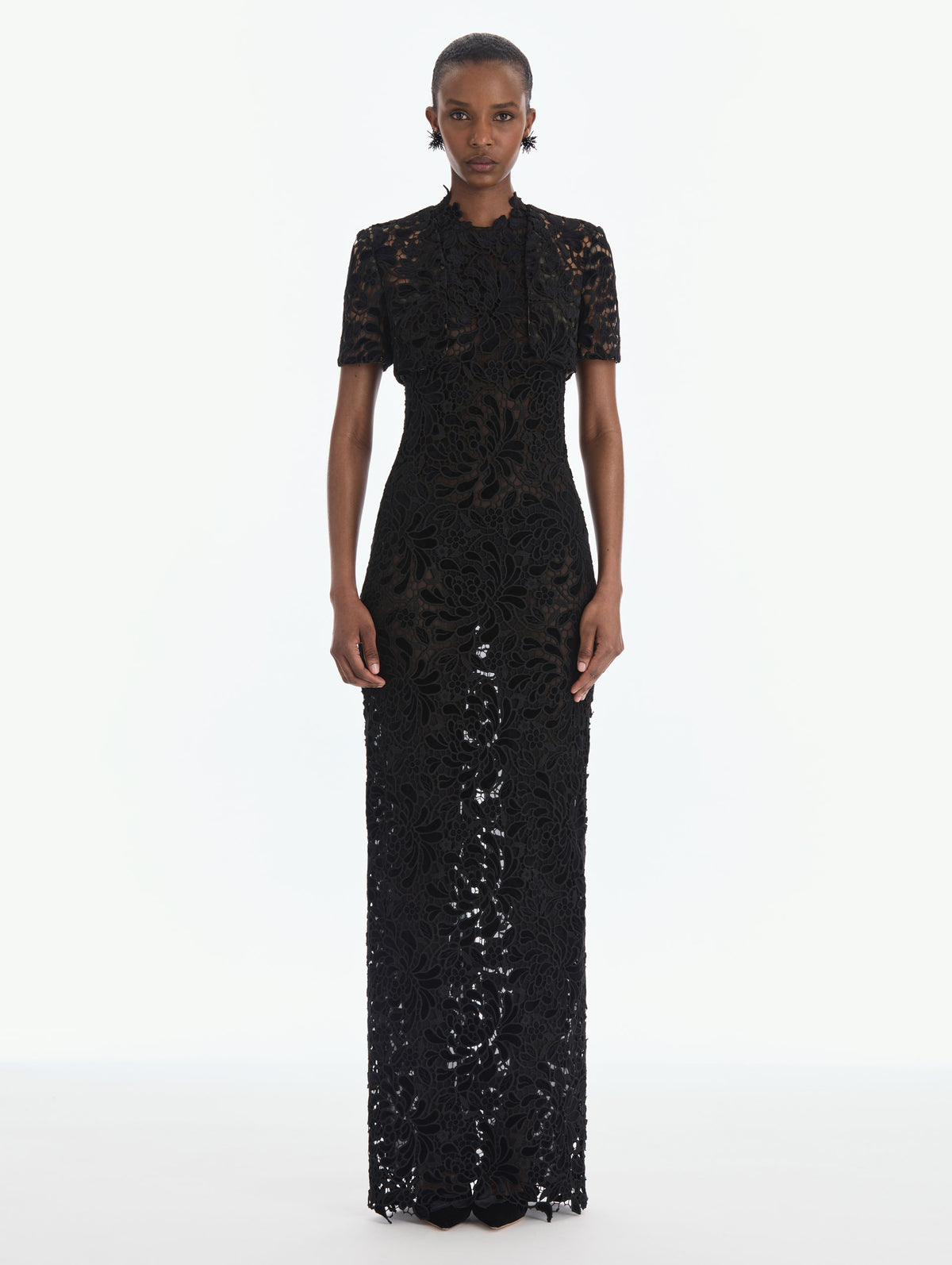 The model is wearing a short sleeve cape. Back view.