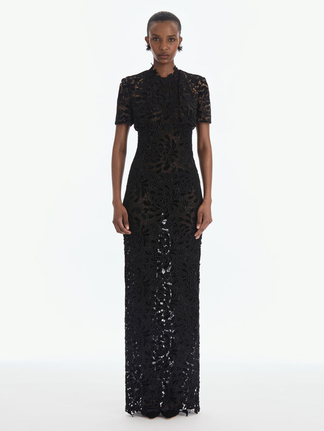The model is wearing a short sleeve cape. Back view.