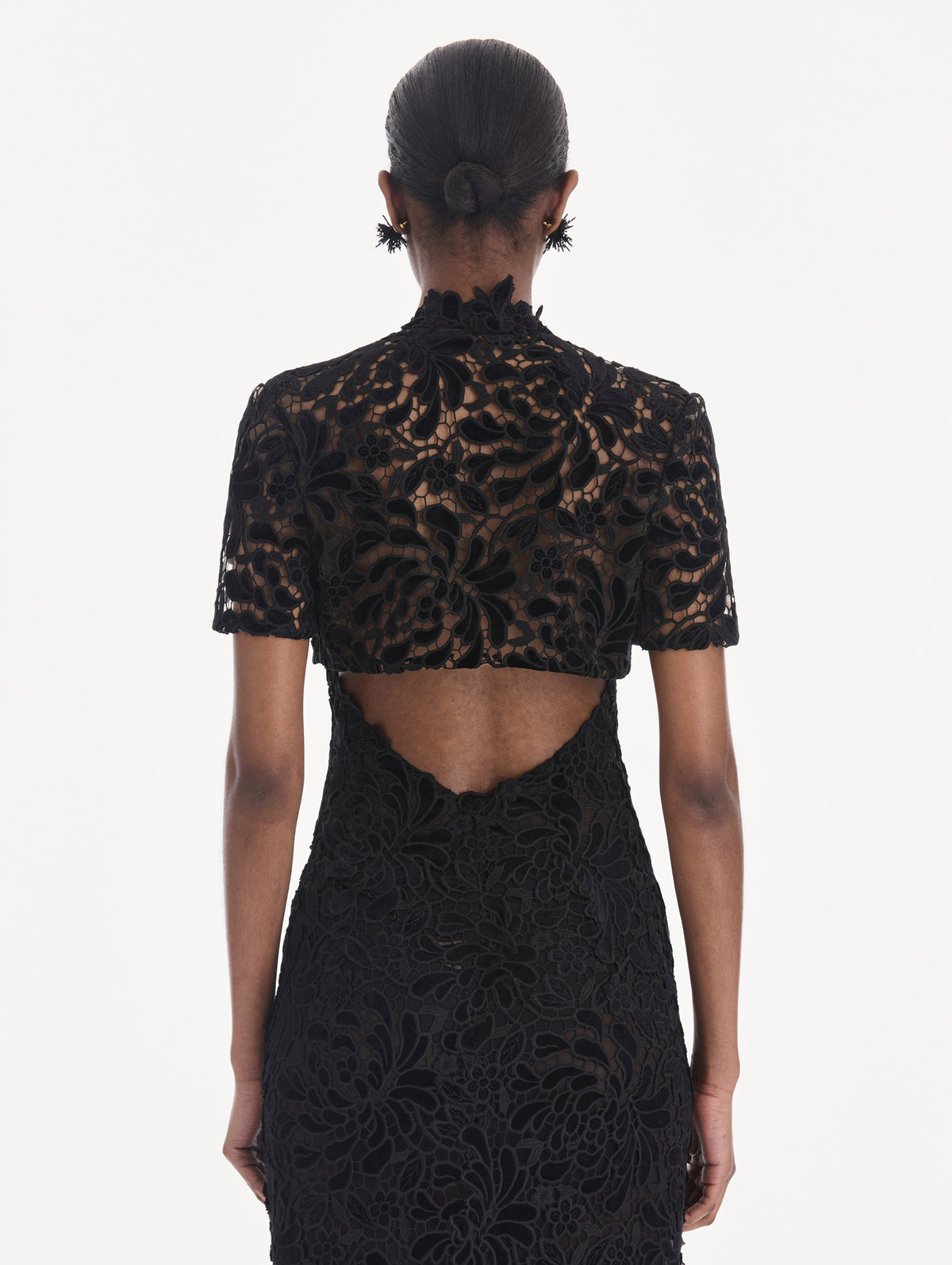 The model is wearing a short sleeve cape. Side view.