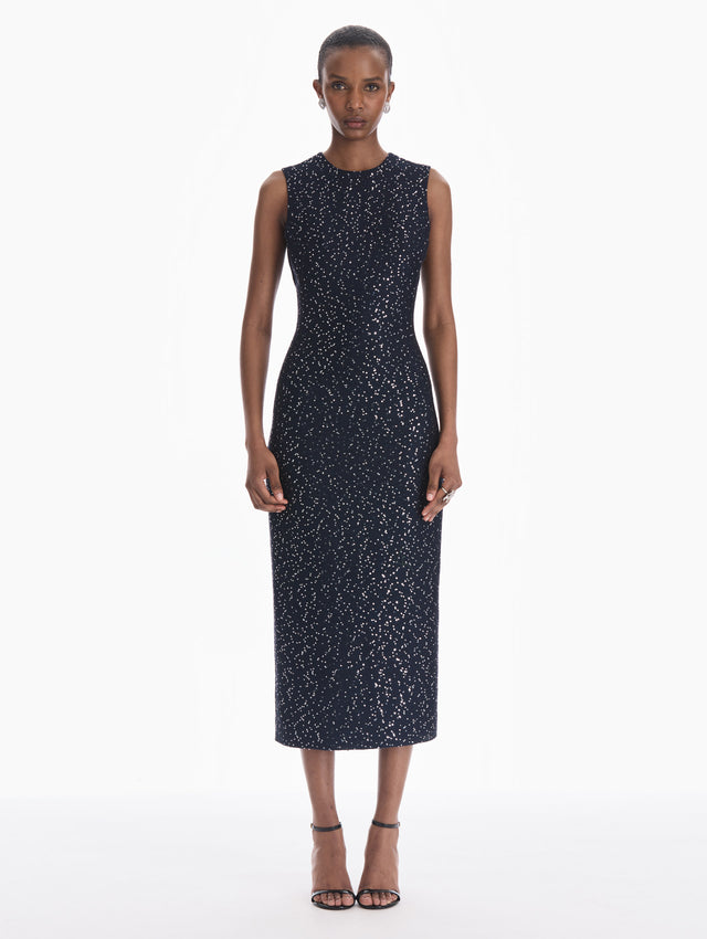 The model is wearing a sleeveless sequin tweed cocktail dress in navy. Front view.