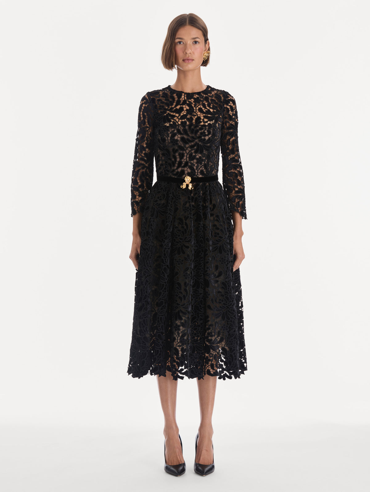 The model is wearing a long sleeve chrysanthemum guipure cocktail dress. Front view.