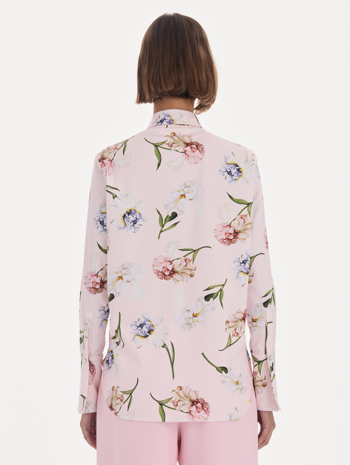 The model is wearing a long sleeve painted iris poplin blouse. Back view.