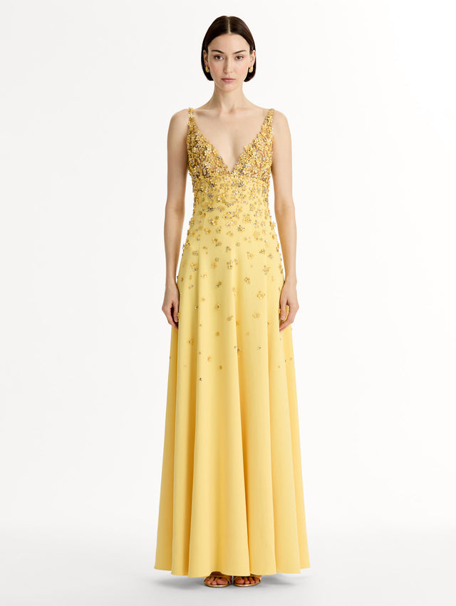 Sleeveless, open back, Yellow v-neck gown with porcelain-flower motifs rendered in sequins and crystals along neckline and bodice, tapering into the skirt. Front View. 