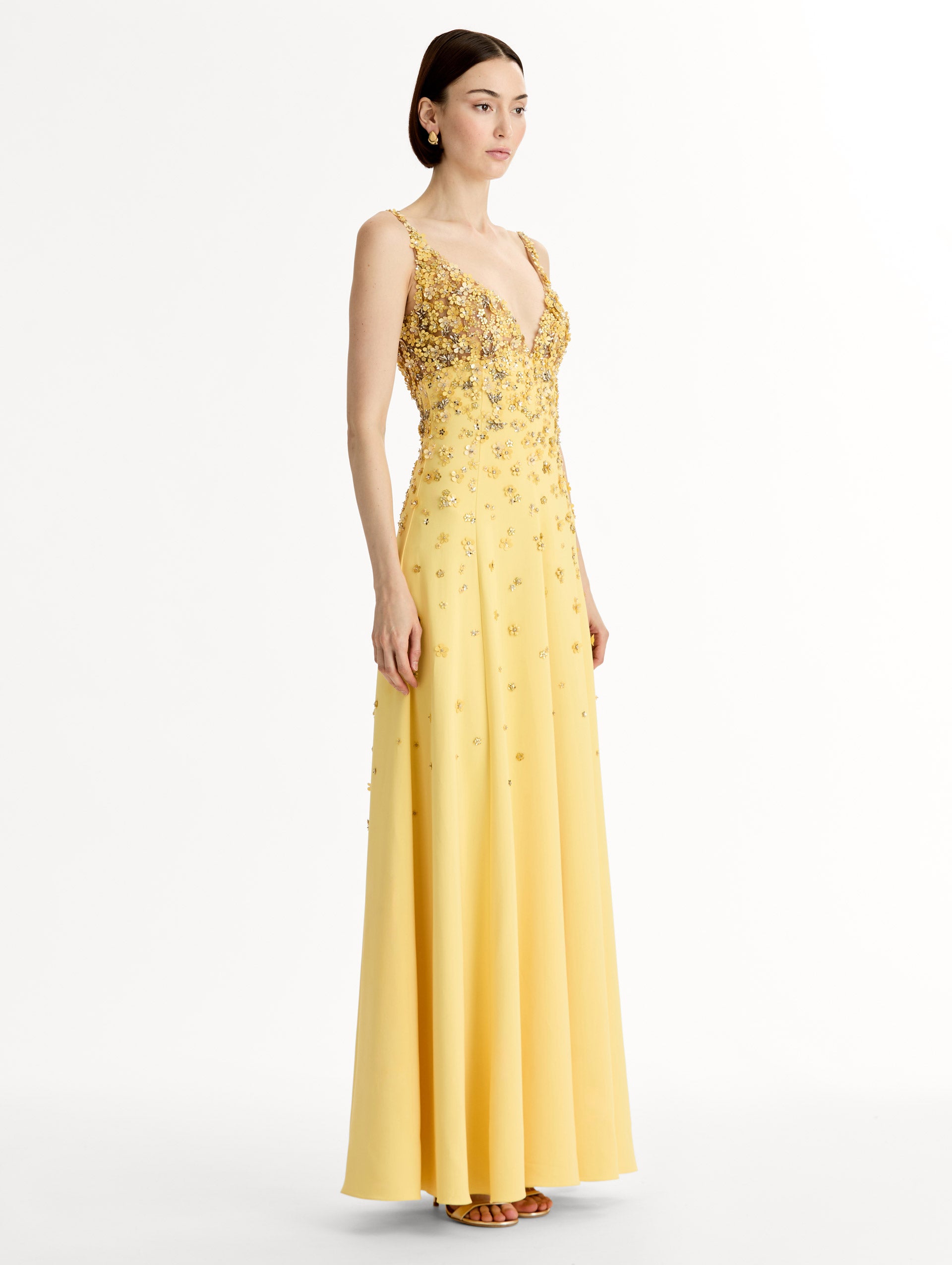 Sleeveless, open back, Yellow v-neck gown with porcelain-flower motifs rendered in sequins and crystals along neckline and bodice, tapering into the skirt. Side View. 
