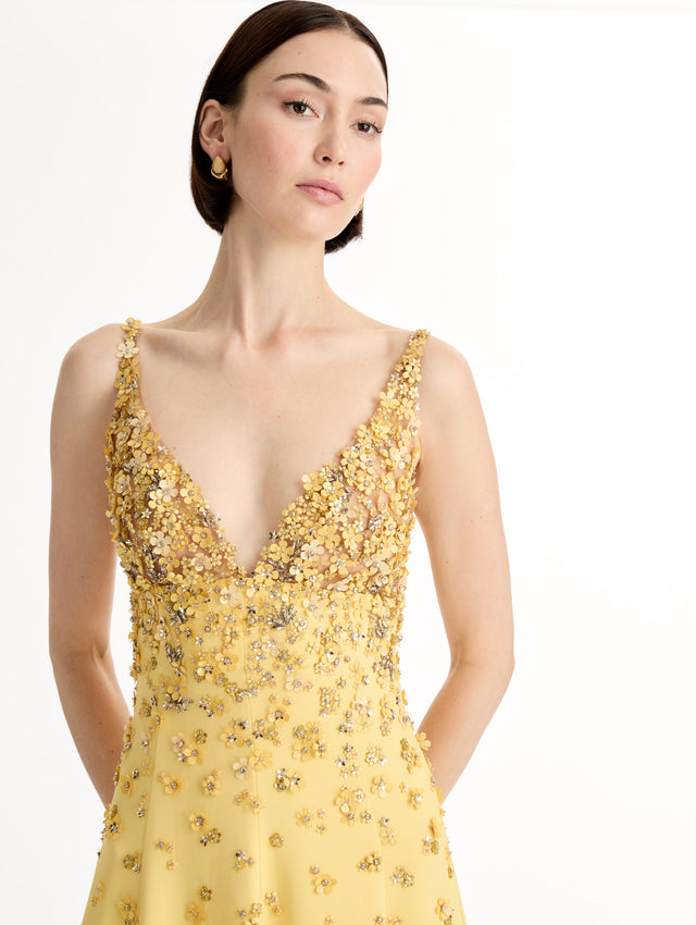 Sleeveless, open back, Yellow v-neck gown with porcelain-flower motifs rendered in sequins and crystals along neckline and bodice, tapering into the skirt. Front View, Close Up. 
