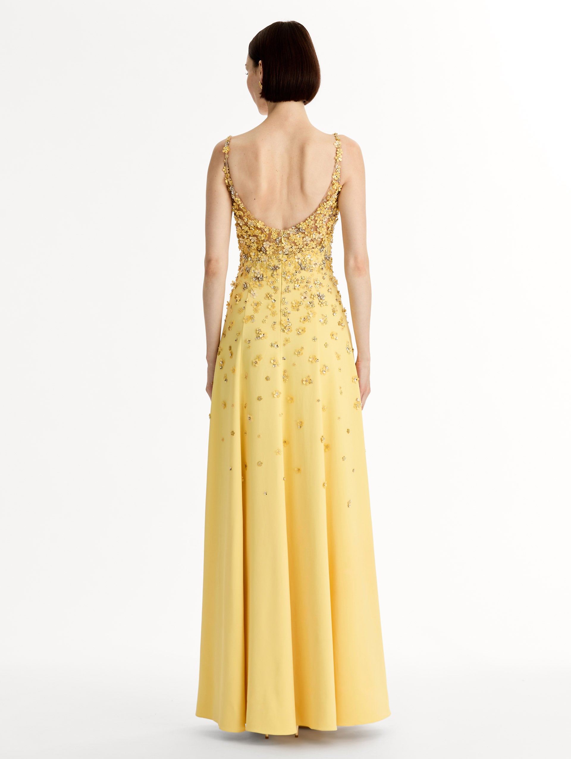 Sleeveless, open back, Yellow v-neck gown with porcelain-flower motifs rendered in sequins and crystals along neckline and bodice, tapering into the skirt. Back View. 