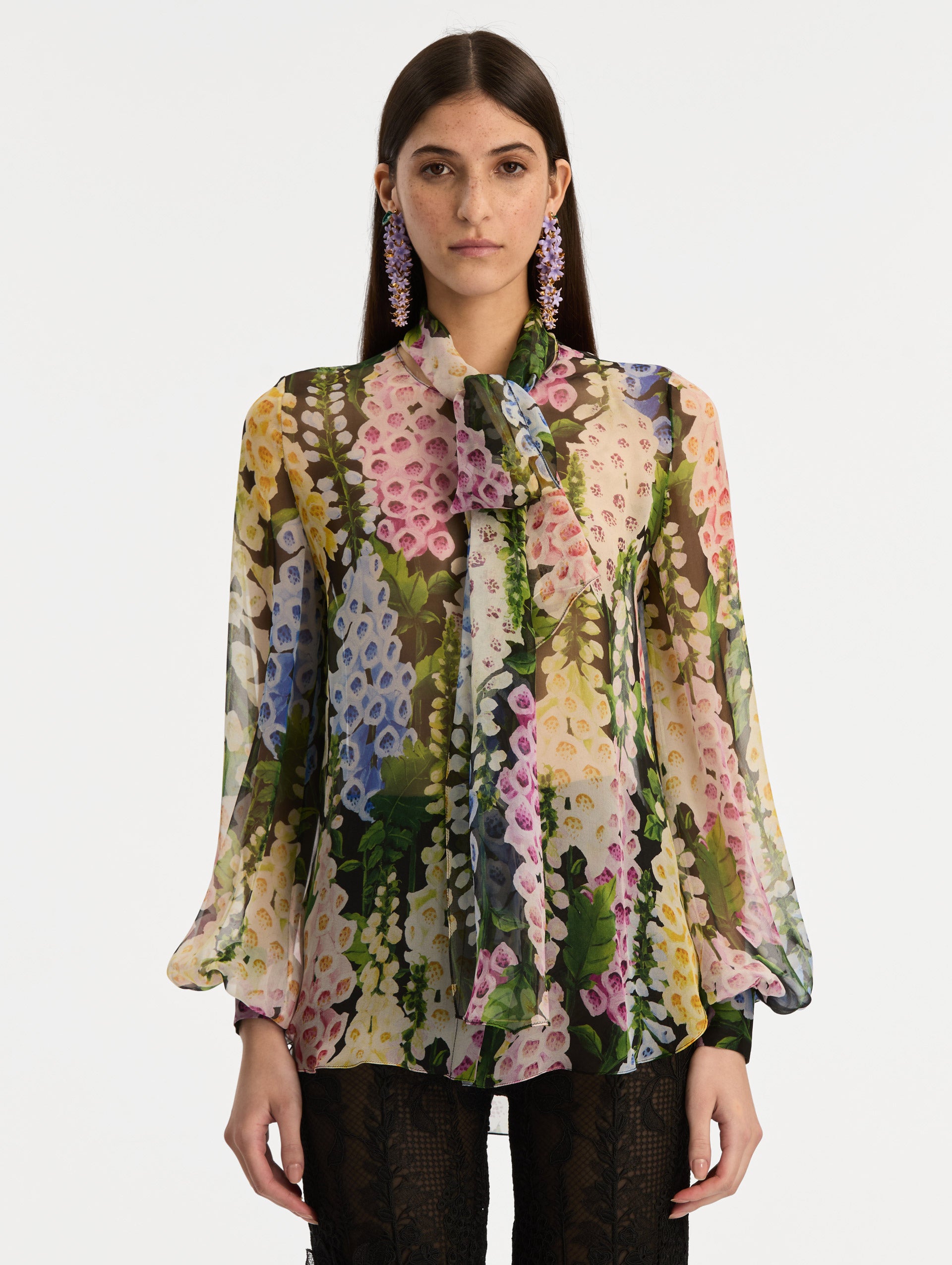 Black and floral Foxglove Tie-Neck Chiffon Blouse with billowing long sleeves with cuffed wrists. Front View.