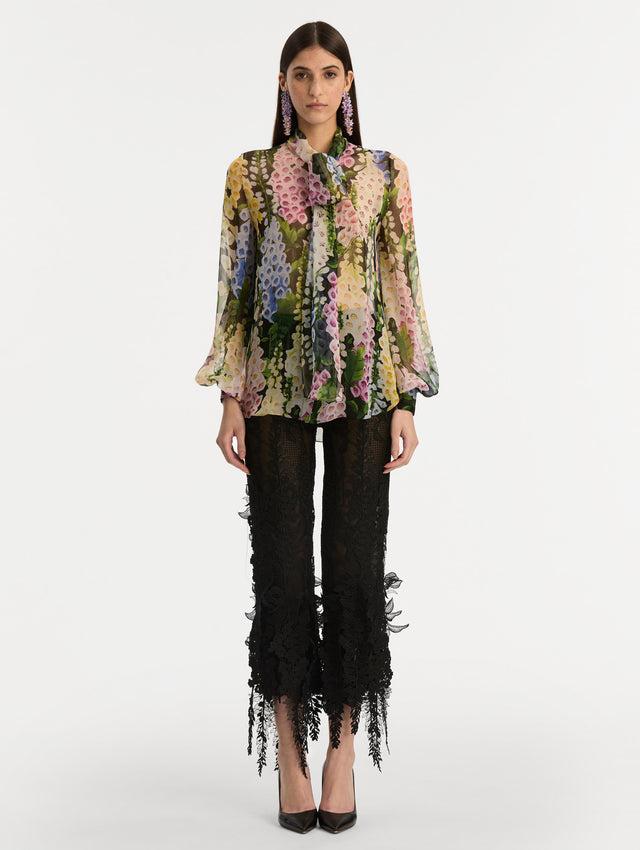 Black and floral Foxglove Tie-Neck Chiffon Blouse with billowing long sleeves with cuffed wrists. Front View.