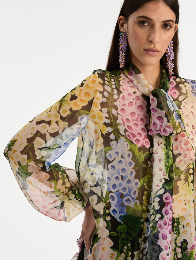 Black and floral Foxglove Tie-Neck Chiffon Blouse with billowing long sleeves with cuffed wrists. Zoom View.