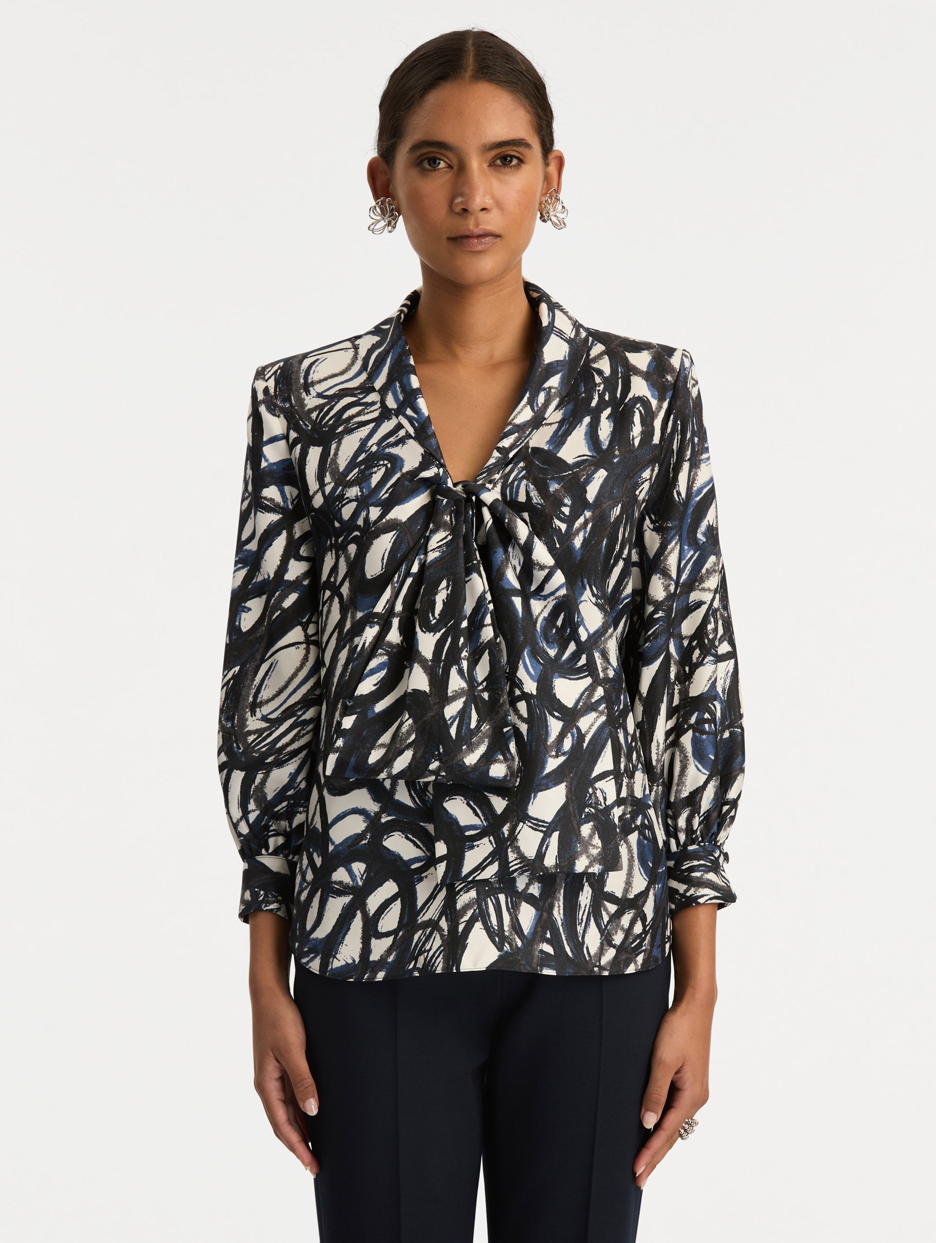 White and Blue Abstract Sketch Silk Twill Blouse featuring a deep V-neckline with knotted drape detail and long sleeves. Front View.