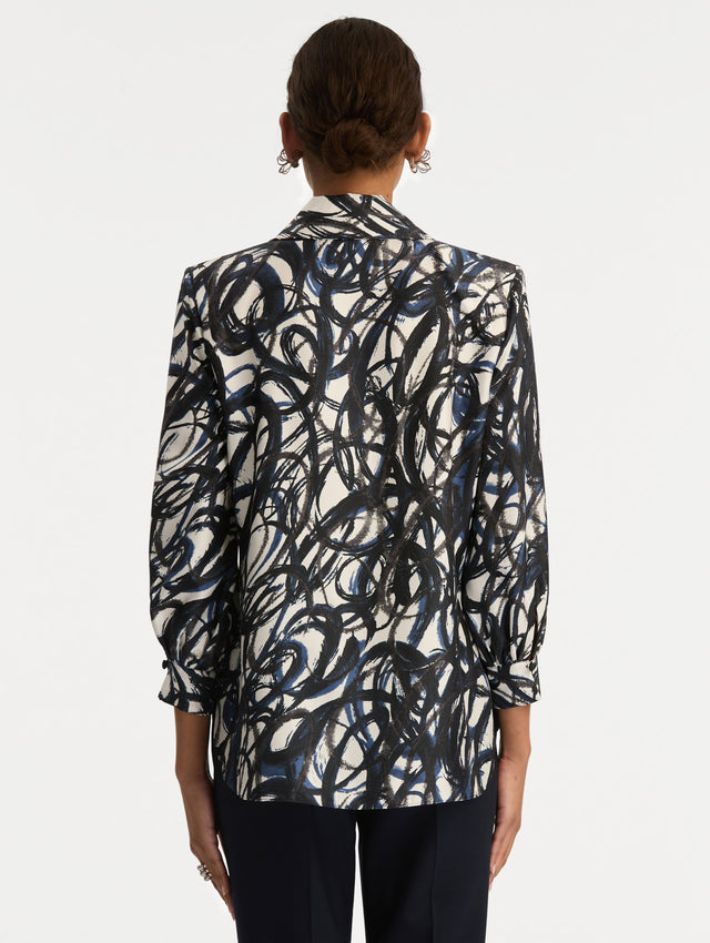 White and Blue Abstract Sketch Silk Twill Blouse featuring a deep V-neckline with knotted drape detail and long sleeves. Back View.