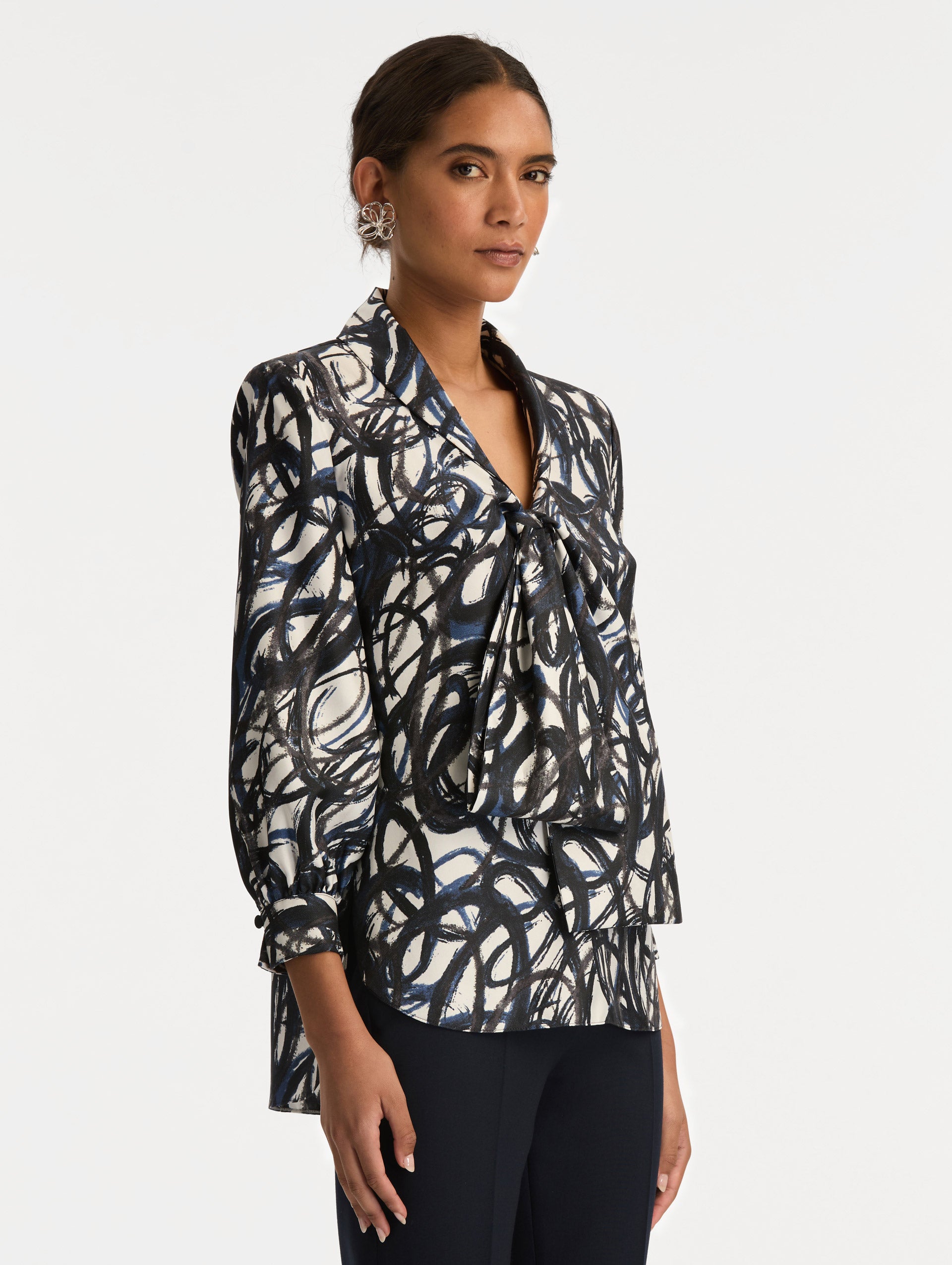 White and Blue Abstract Sketch Silk Twill Blouse featuring a deep V-neckline with knotted drape detail and long sleeves. Side View.
