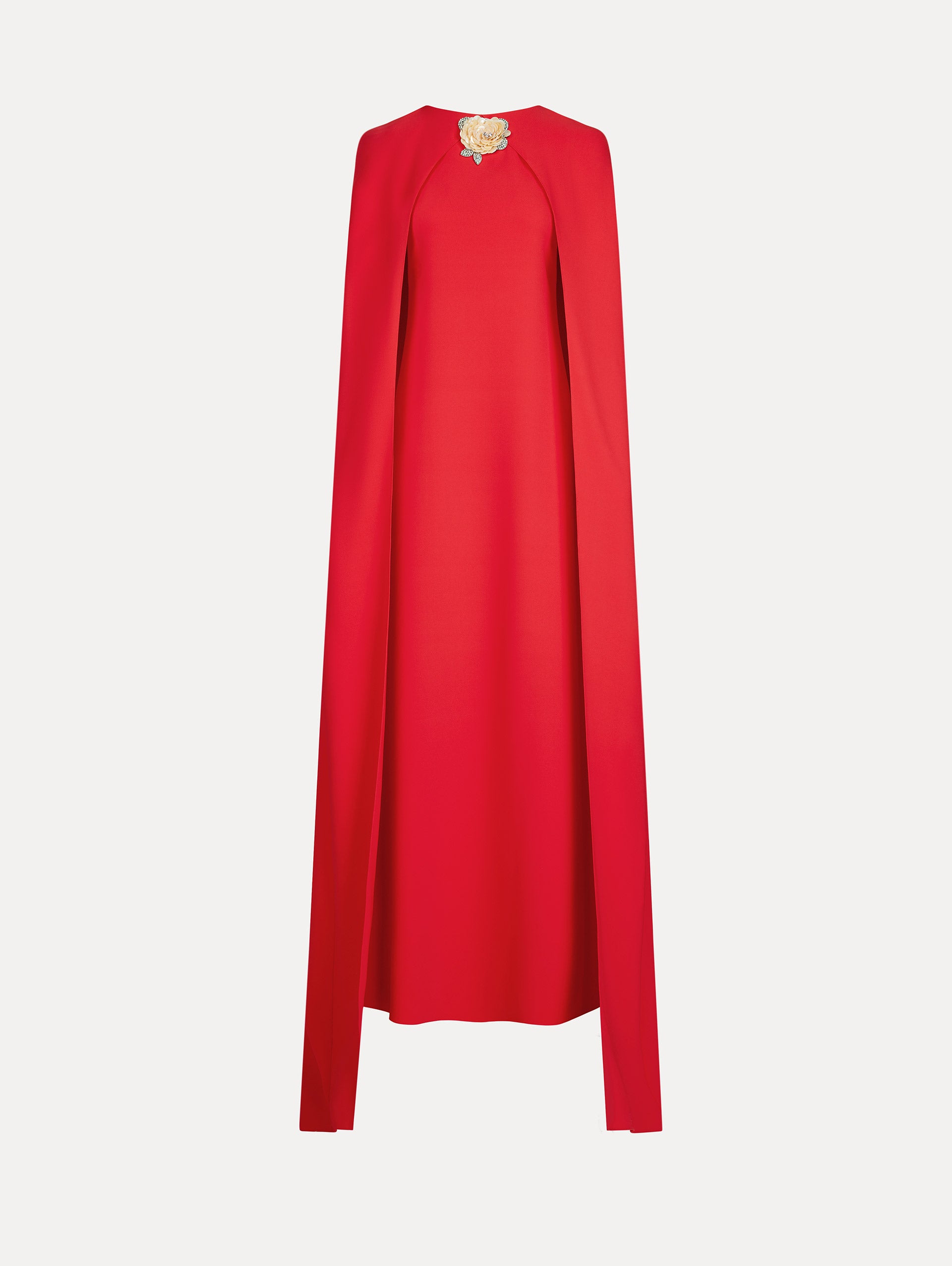 The Brooch Embroidered Cape-Back Caftan in the color red featuring draped sleeves and a floral brooch at center neckline. Front View.