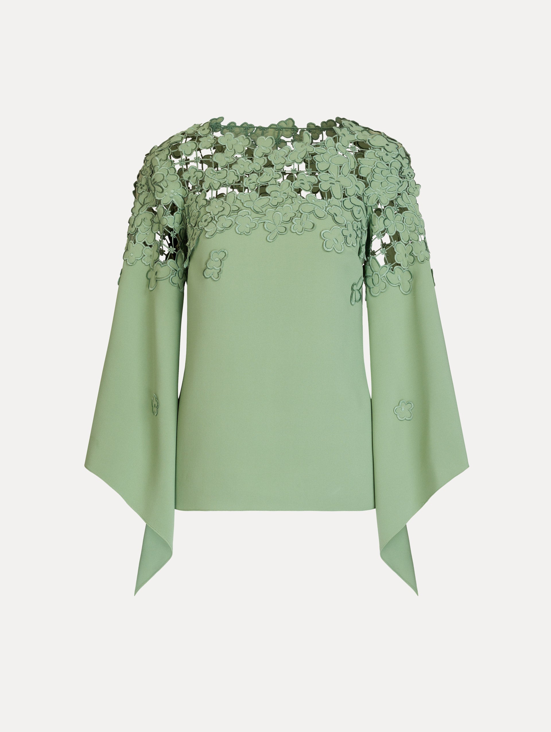 The Floral Appliqué Lattice Blouse in green featuring a floral, open lattice neckline and long, flowy sleeves. Front View.