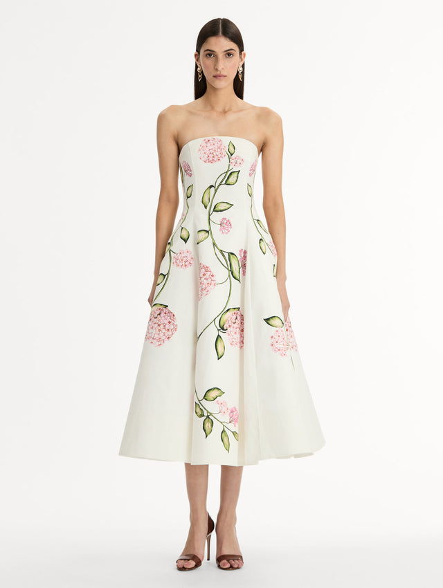 White, strapless cotton poplin midi dress.  Sculpted bodice with flared skirt. vivid pink flower print. Front View. 