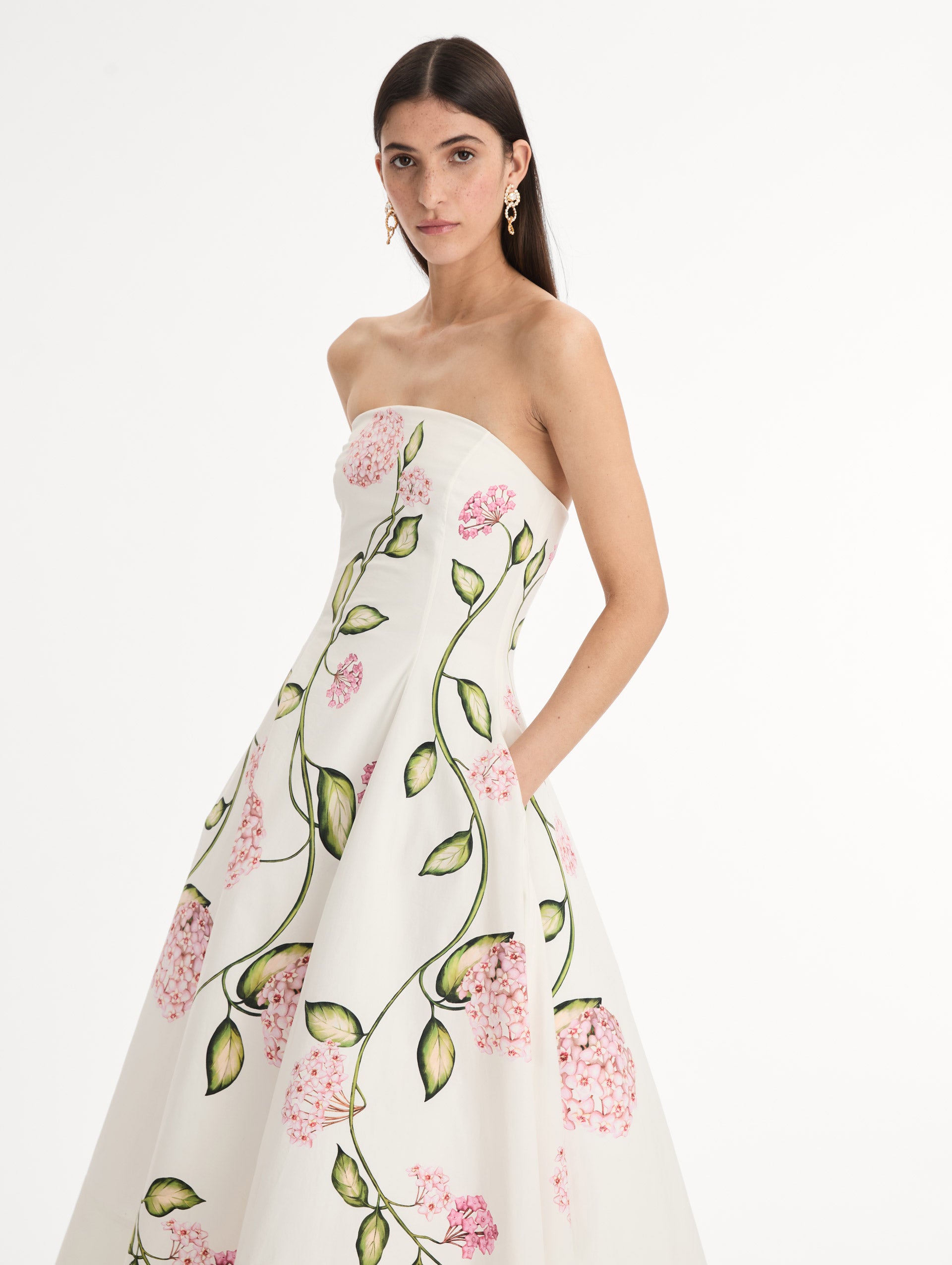 White, strapless cotton poplin midi dress.  Sculpted bodice with flared skirt. vivid pink flower print. Side View. 