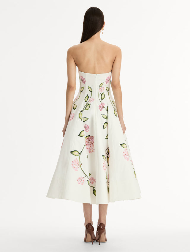 White, strapless cotton poplin midi dress.  Sculpted bodice with flared skirt. vivid pink flower print. Back View. 