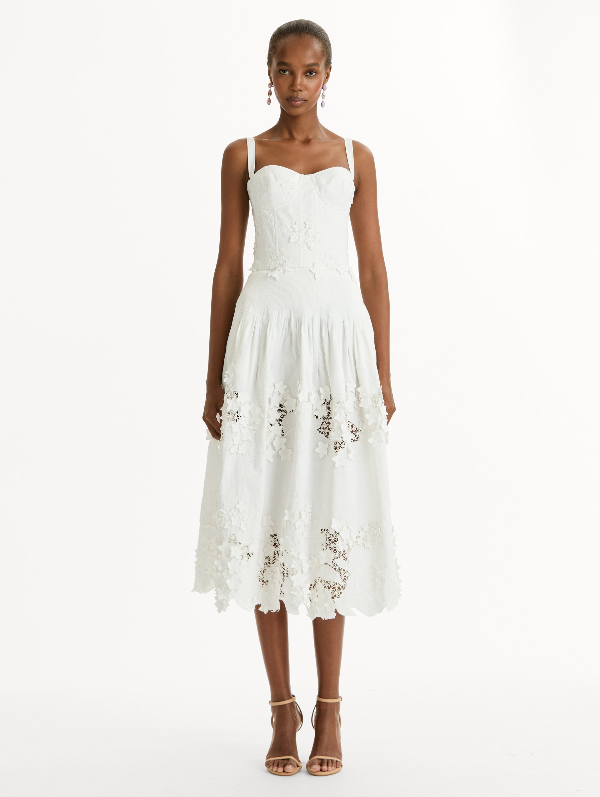 Cotton stretch twill dress. Sculpted bustier bodice with full, midi-length skirt.  porcelain-flower guipure lace along hem. Three-dimensional floral appliqués in layered white-on-white texture. Front View.