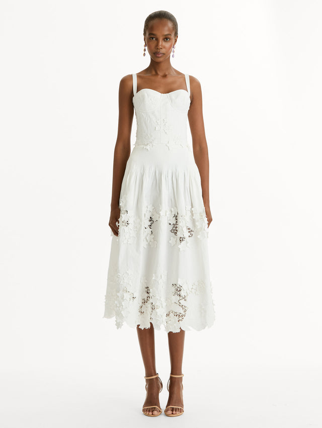 Cotton stretch twill dress. Sculpted bustier bodice with full, midi-length skirt.  porcelain-flower guipure lace along hem. Three-dimensional floral appliqués in layered white-on-white texture. Front View.