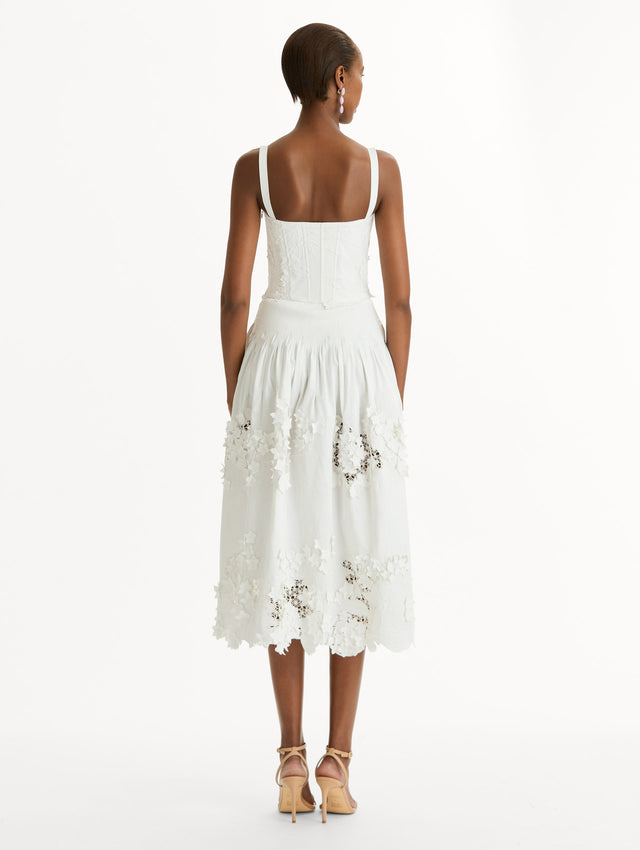 Cotton stretch twill dress. Sculpted bustier bodice with full, midi-length skirt.  porcelain-flower guipure lace along hem. Three-dimensional floral appliqués in layered white-on-white texture. Back View.