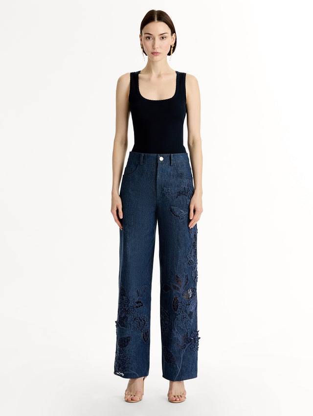 Mid-rise denim pants with intricate porcelain flower threadwork and cutout detailing. Front View.