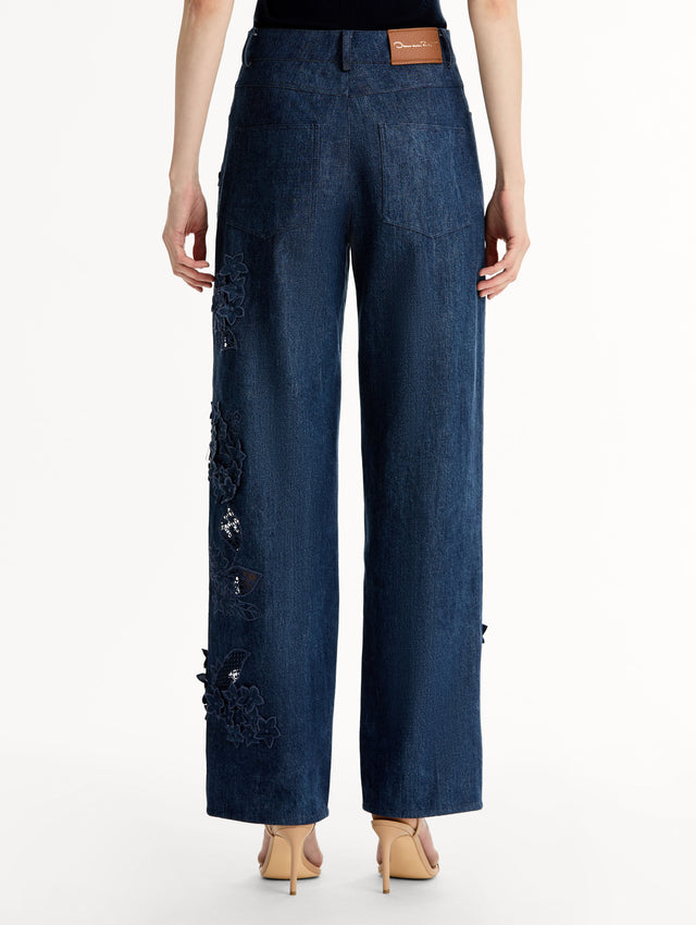 Mid-rise denim pants with intricate porcelain flower threadwork and cutout detailing. Back View.