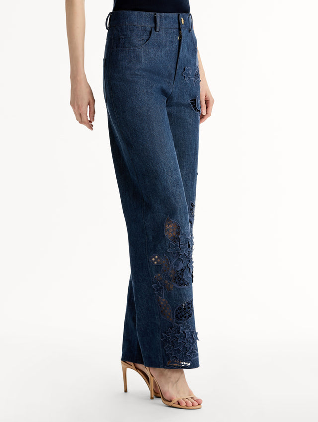 Mid-rise denim pants with intricate porcelain flower threadwork and cutout detailing. Side View.