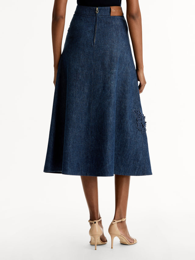 High waisted denim skirt with intricate porcelain flower threadwork. Classic A-line silhouette. Mid length. Back View. 