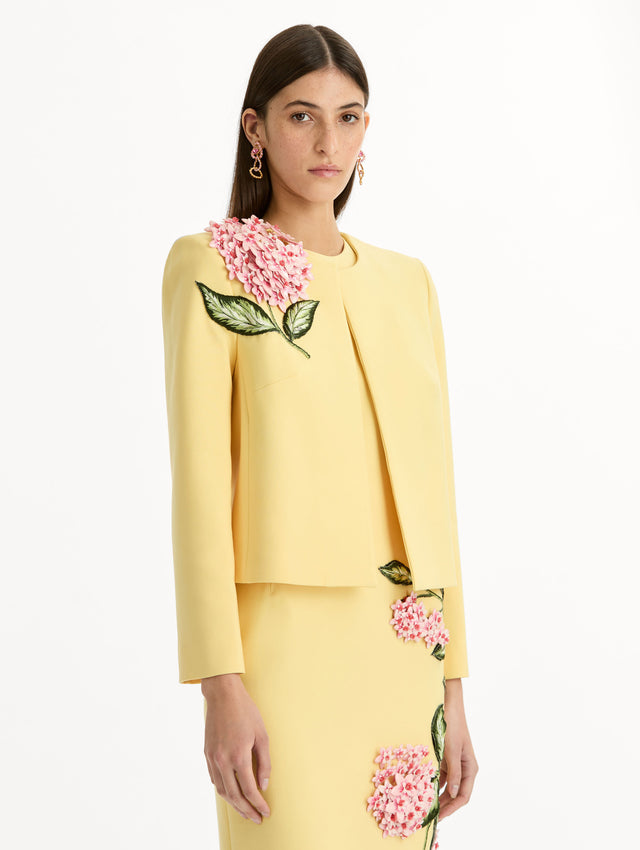 Cropped yellow jacket tailored from double-faced stretch wool and finished with sculptural porcelain flower embroidery at the shoulder. Side View.