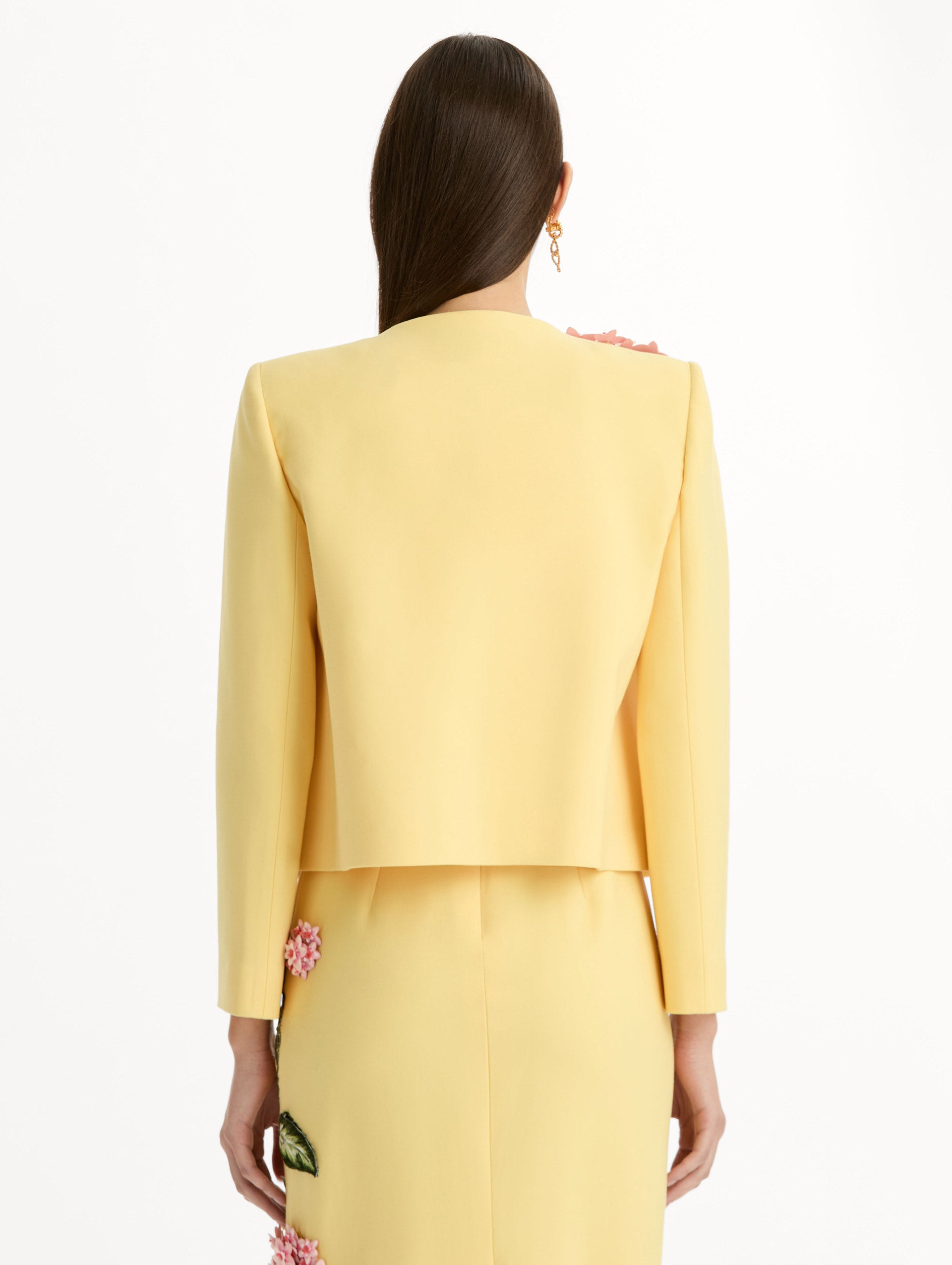 Cropped yellow jacket tailored from double-faced stretch wool and finished with sculptural porcelain flower embroidery at the shoulder. Back View.