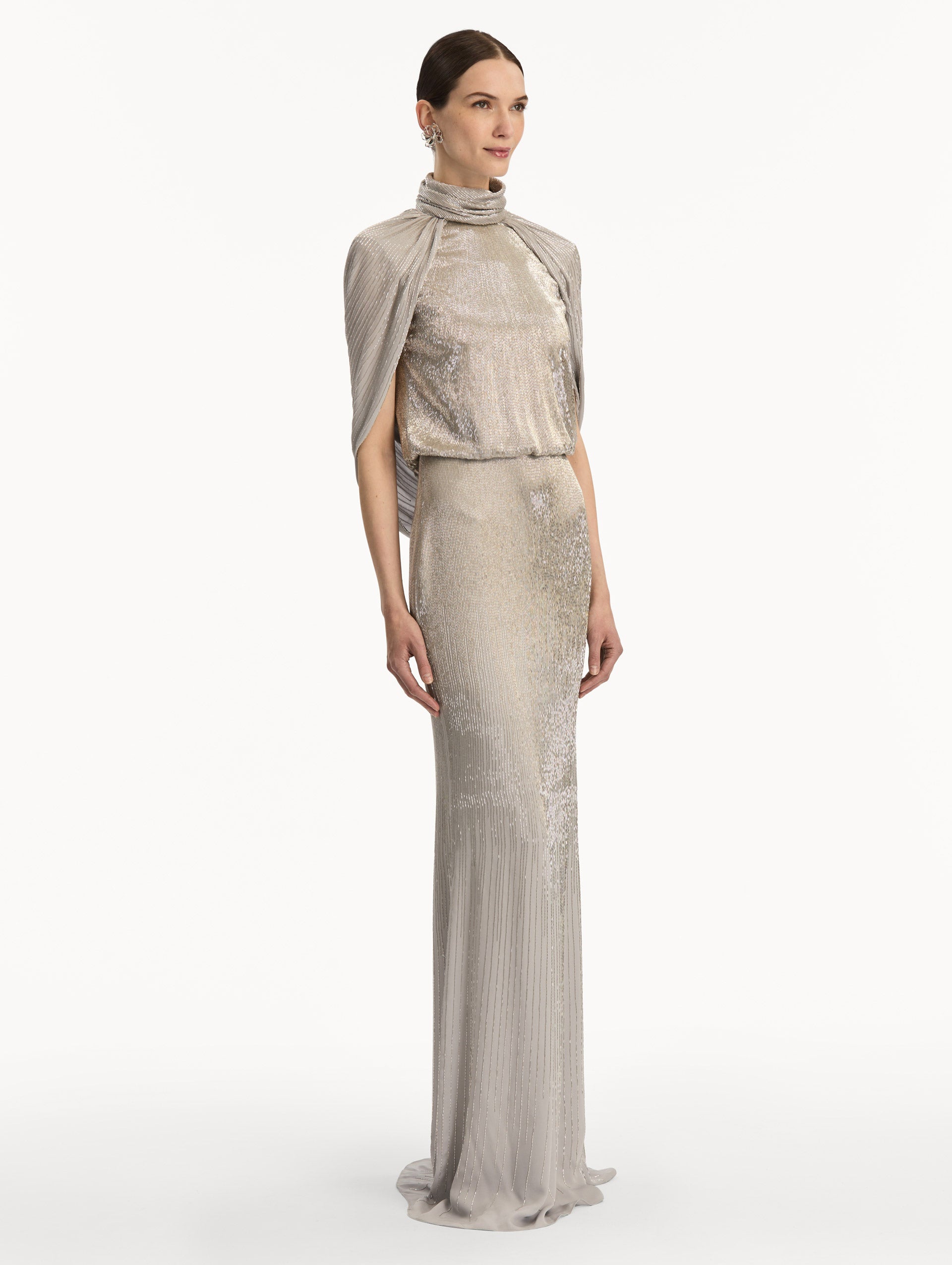 Silver Bugle Bead Lamé Draped Gown with a high neckline, draped cape sleeves, and metallic finish. Side View.