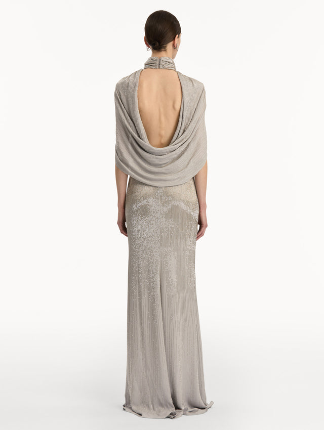Silver Bugle Bead Lamé Draped Gown with a high neckline, draped cape sleeves, and metallic finish. Back View.