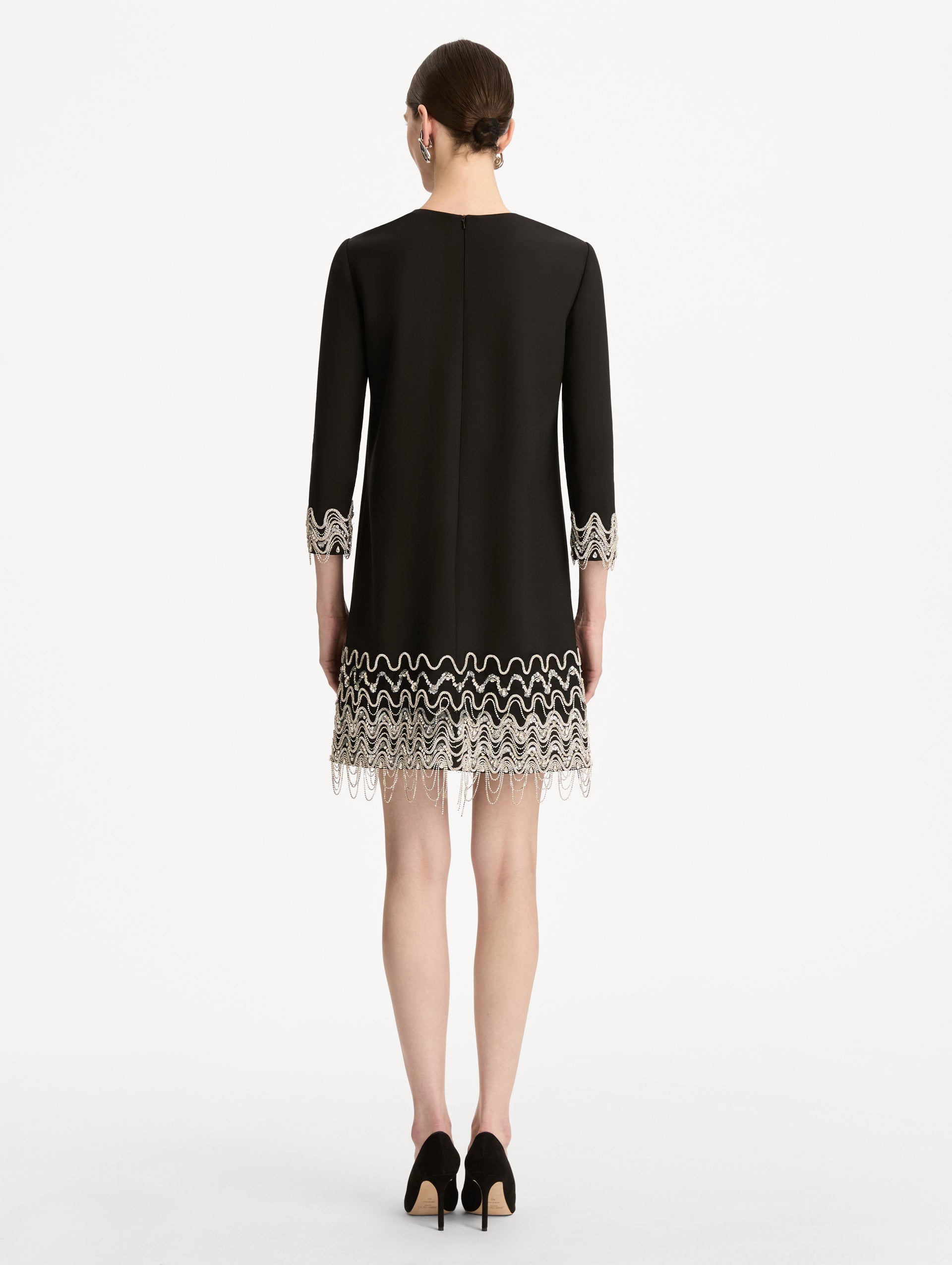 Black Crystal Wave Embroidered Shift Dress with long sleeves and beaded embellishments along the hemline and sleeve cuffs. Back View.