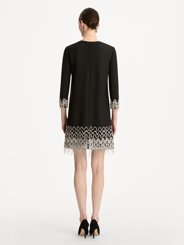 Black Crystal Wave Embroidered Shift Dress with long sleeves and beaded embellishments along the hemline and sleeve cuffs. Back View.