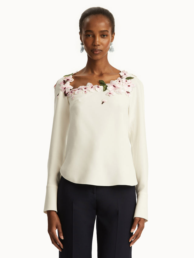 White blouse with cherry embroidered detail around the neck. Front View.