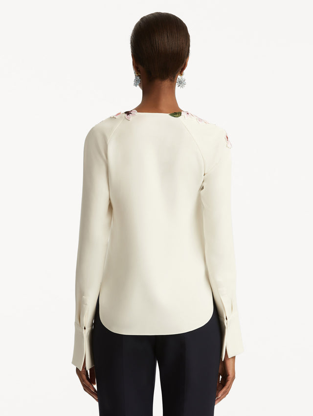 White blouse with cherry embroidered detail around the neck. Back View.