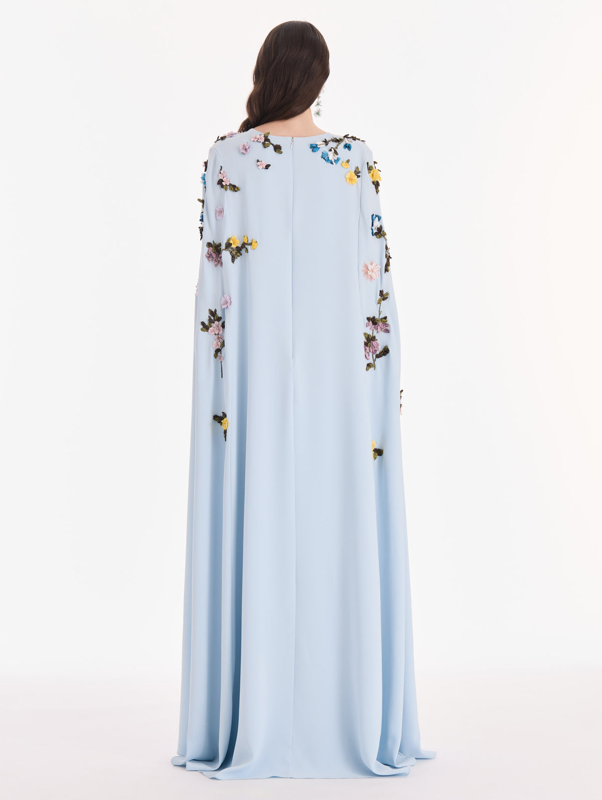 The model is wearing a draped sleeve mixed botanical on lace caftan. Back view.