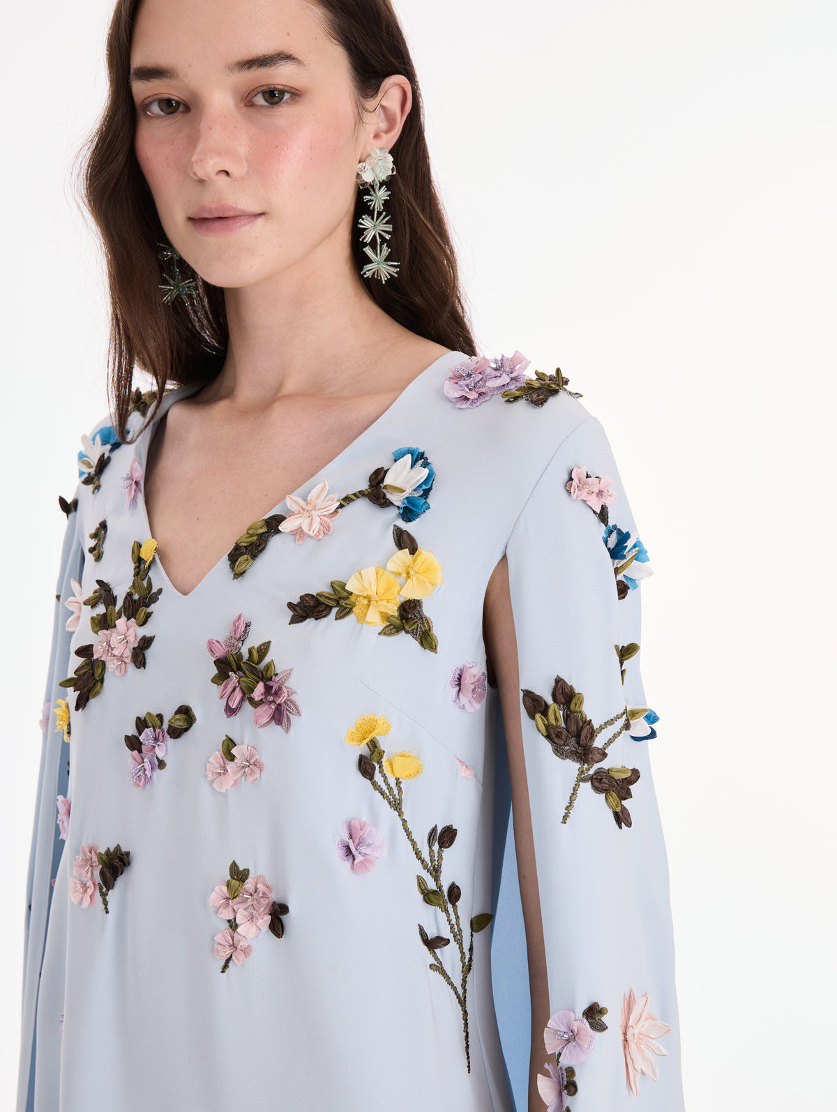 The model is wearing a draped sleeve mixed botanical on lace caftan. Zoom view.