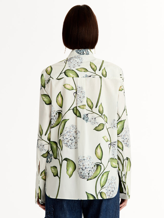 Porcelain flower print on cotton poplin blouse. Tailored silhouette and concealed button front. Threadwork cutout detailing. High Neckline. Back View.