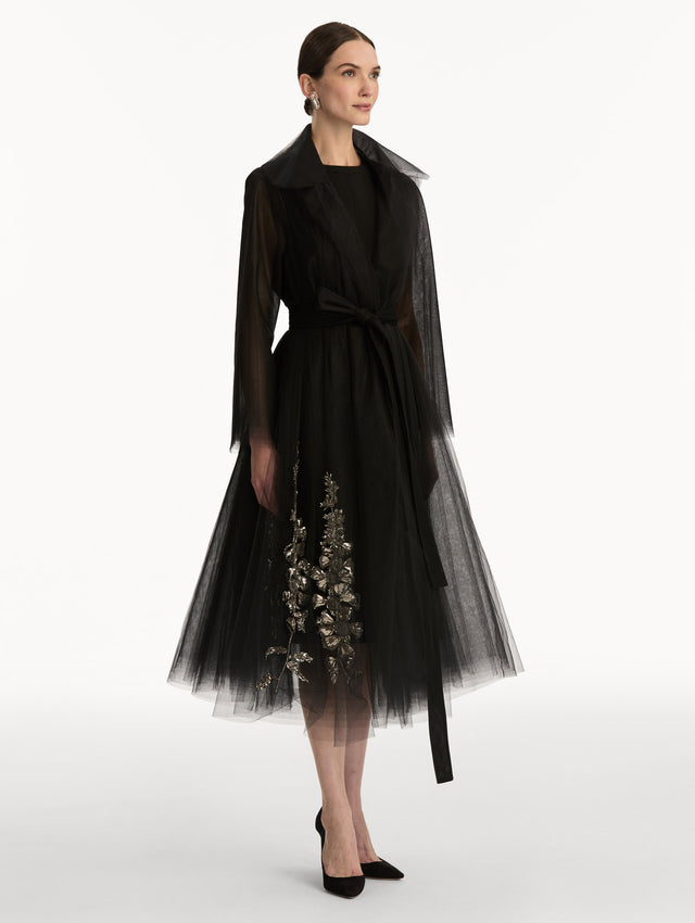 Black Foxglove Sequin Embroidered Opera Coat featuring a belted waist, wide collar, and embroidered floral detailing over a midi-length silhouette. Side View.