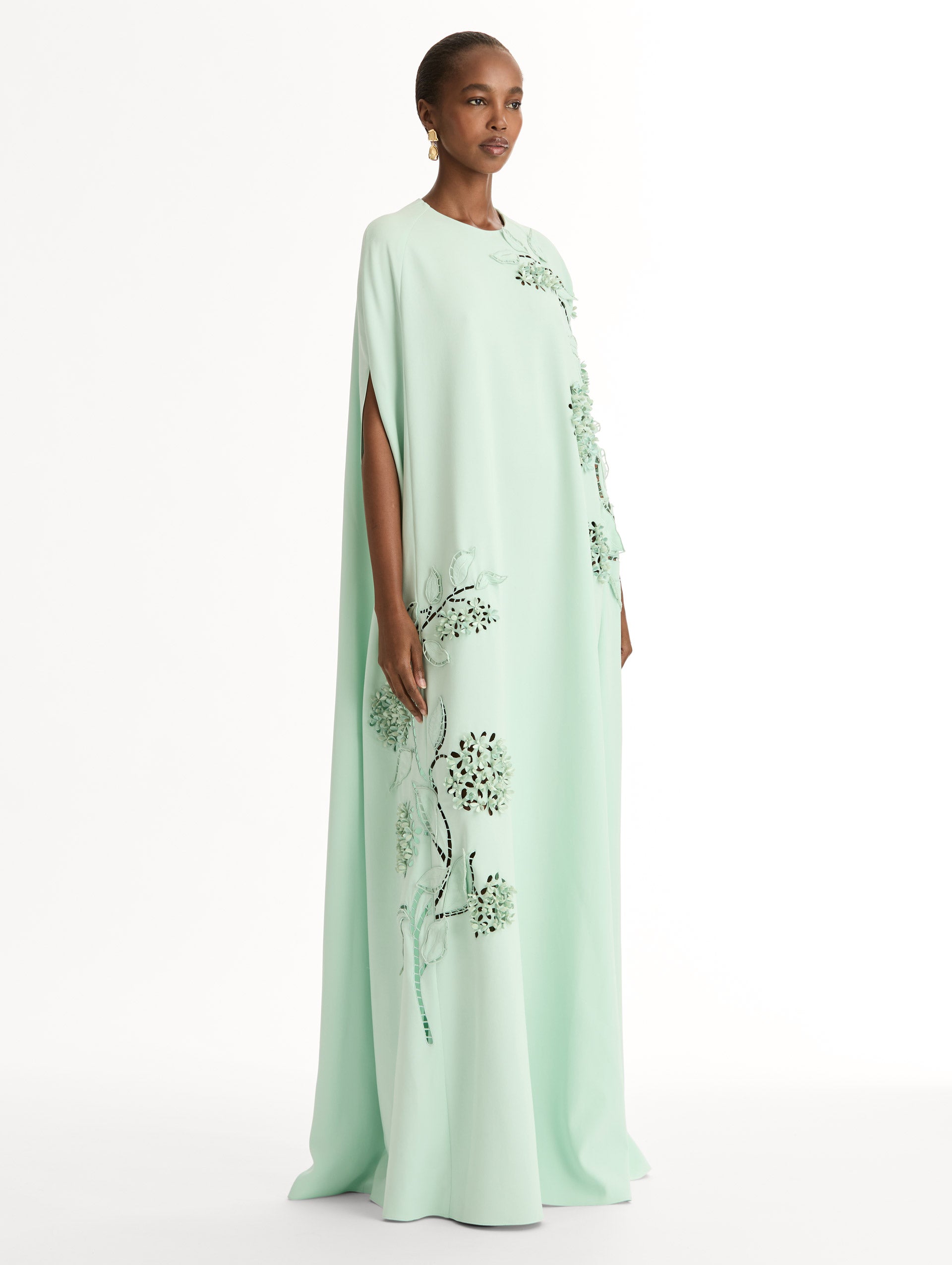 Mint caftan in heavy silk stretch georgette. Porcelain-flower threadwork cutouts.  Dimensional petals and delicately openwork stems. Side View. 