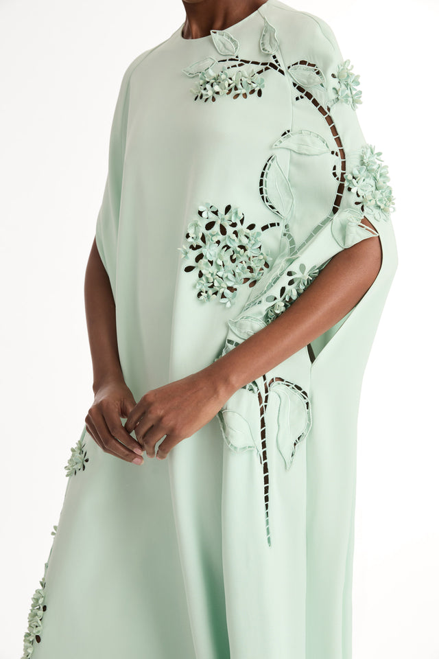 Mint caftan in heavy silk stretch georgette. Porcelain-flower threadwork cutouts.  Dimensional petals and delicately openwork stems. Close Up Side View. 