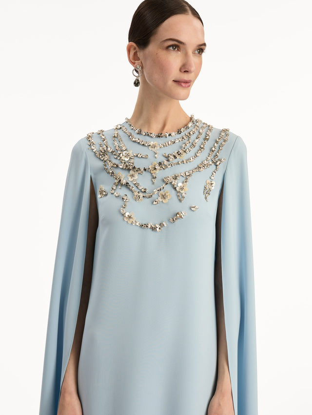 Light Blue Crystal Necklace Embroidered Caftan featuring a floor-length silhouette with draped sleeves and crystal embellishment along the neckline. Zoom View.