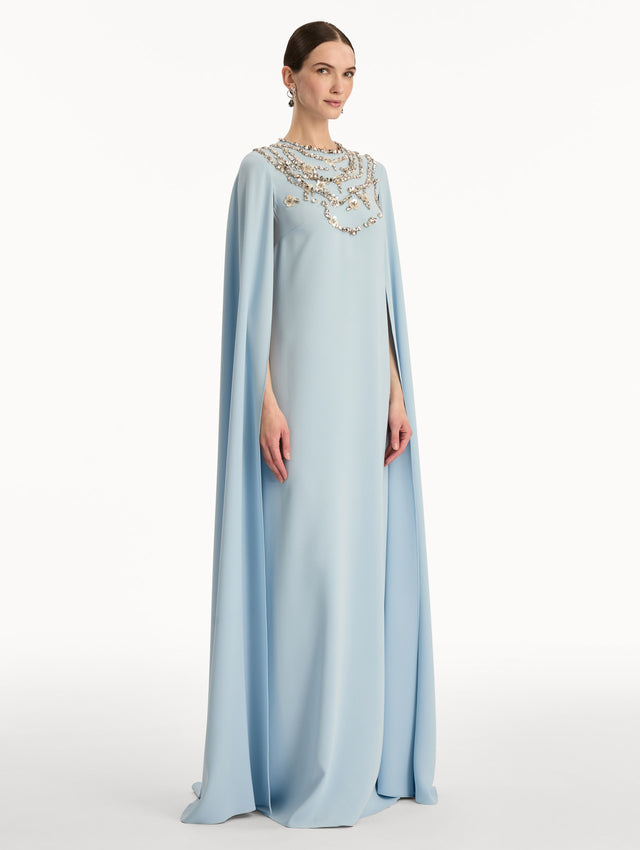 Light Blue Crystal Necklace Embroidered Caftan featuring a floor-length silhouette with draped sleeves and crystal embellishment along the neckline. Side View.
