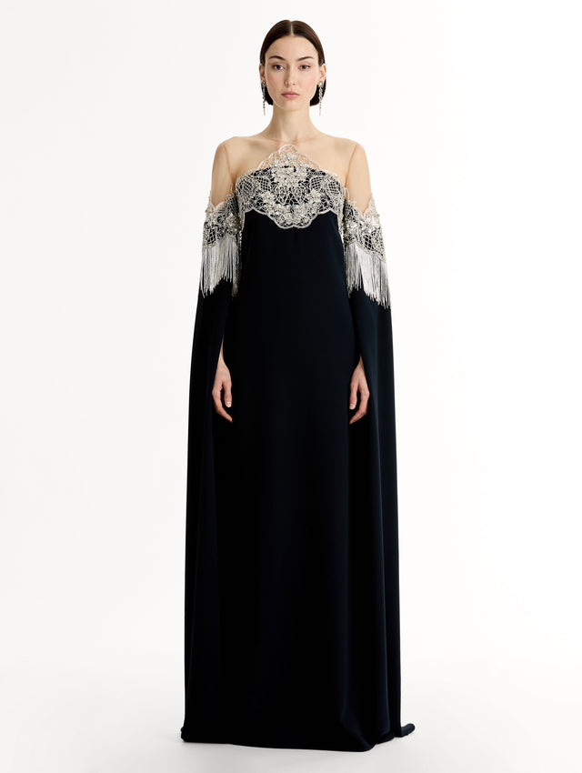 Caftan with sheer illusion tulle neckline and porcelain flower lattice. Hand-applied bugle beads around each motif, and fluid bugle bead fringe on sleeves. Front View. 